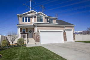 View of front of property featuring brick siding, driveway, covered porch, and a garage