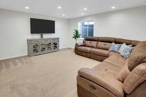 Living area with recessed lighting and light colored carpet