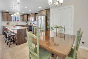 Dining room with a chandelier and light tile patterned flooring