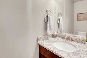 Half bathroom with vanity and toilet