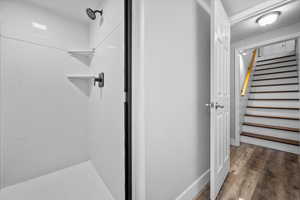 Full bath with a shower stall, dark wood-type flooring, and a textured ceiling