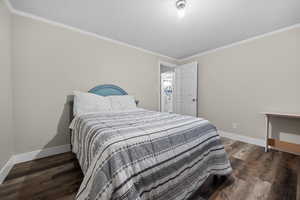 Bedroom with dark wood-type flooring and ornamental molding