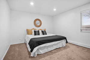Bedroom with carpet floors, baseboard heating, and recessed lighting