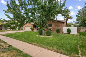 View of front of property featuring brick siding, concrete driveway, and a garage