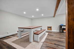 Unfurnished dining area featuring a glass covered fireplace, recessed lighting, light wood-type flooring, and beam ceiling