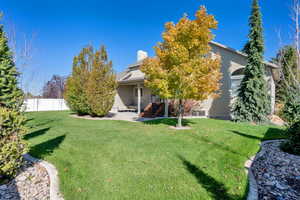 View of front facade featuring a chimney, a patio, and stucco siding