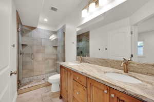 Full bath with double vanity, a shower stall, light tile patterned floors, and recessed lighting