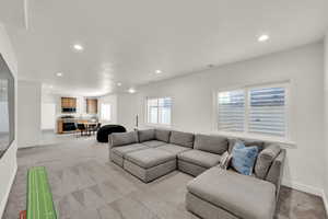 Living area with light colored carpet, recessed lighting, and a textured ceiling