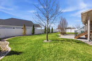 Fenced backyard featuring stairs and a patio