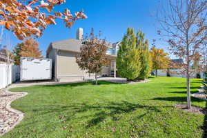 Rear view of property featuring a chimney, a patio area, and stucco siding