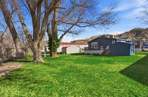View of grassy yard with a deck with mountain view and stairs
