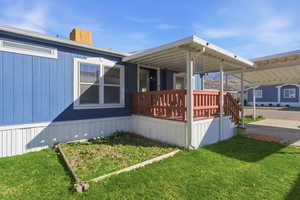 View of home's exterior featuring a lawn, a porch, and a chimney