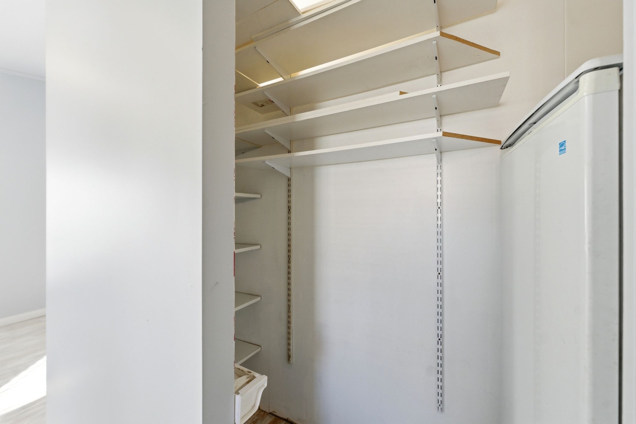 View of walk in closet, storage off Kitchen