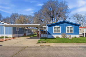 View of home's exterior with a yard, driveway, and a detached carport