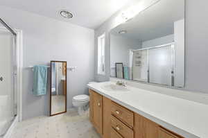 Full bathroom featuring light floors, vanity, and a stall shower