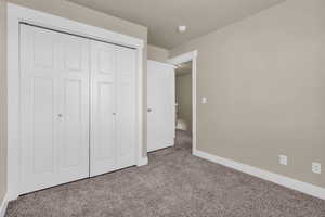 Unfurnished bedroom featuring carpet floors and a closet