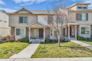 Traditional home featuring a front yard and stone siding