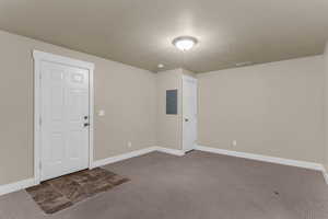 Family room featuring dark carpet, electric panel, and a textured ceiling