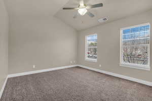 Master with a ceiling fan and lofted ceiling