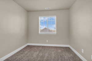 Spare room with carpet and baseboards