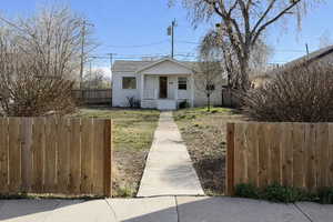 Bungalow with a fenced front yard and a porch