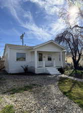 View of front of property featuring covered porch and a shingled roof