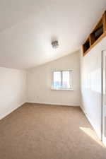 Bedroom #2 with vaulted ceiling and baseboards
