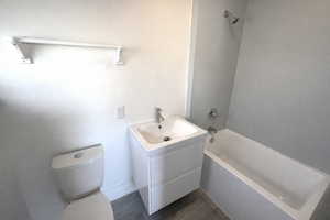Full bath with vanity, tub / shower combination, and dark wood-type flooring