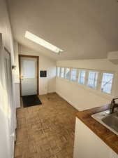 Dining Area featuring a skylight, vaulted ceiling, and parquet floors