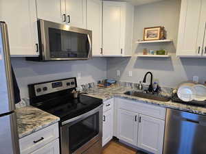 Kitchen with stainless steel appliances and white cabinetry