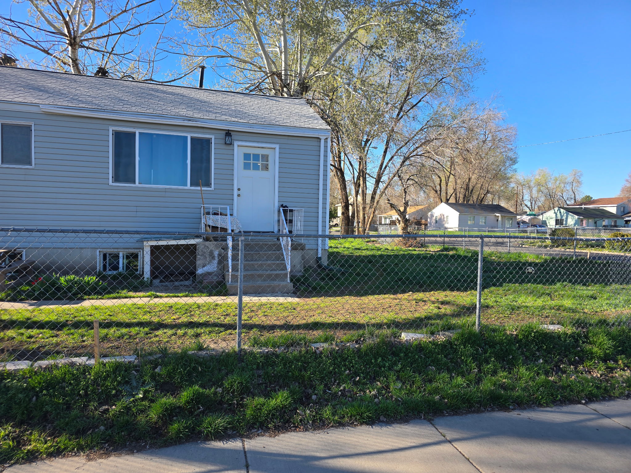 Bungalow featuring a fenced front yard, a shingled roof, and a residential view