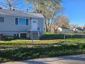 Bungalow featuring a fenced front yard, a shingled roof, and a residential view