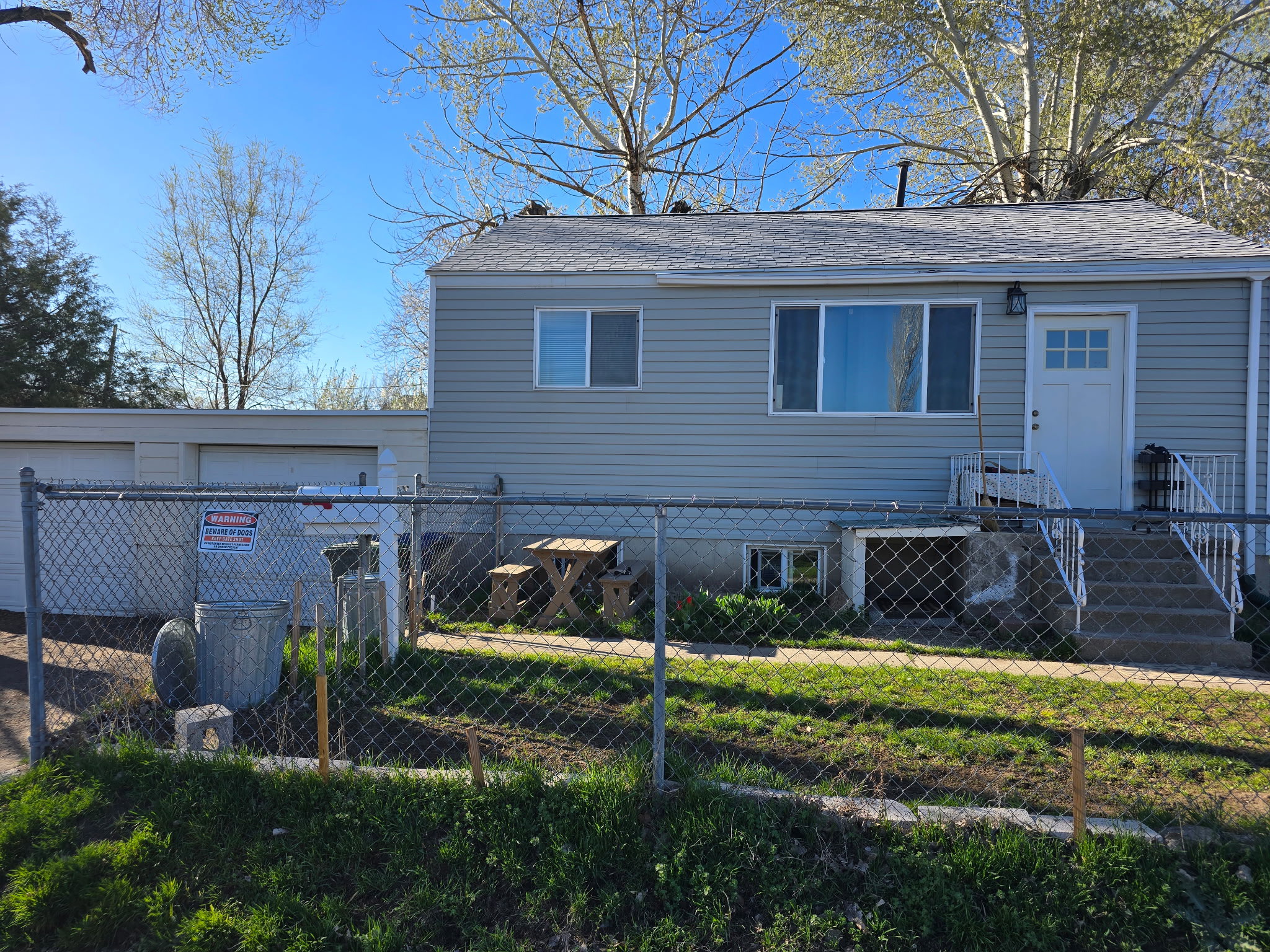 View of front of property with a fenced front yard, roof with shingles, and a garage