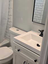 Full bath featuring vanity and shower / bath combo with shower curtain