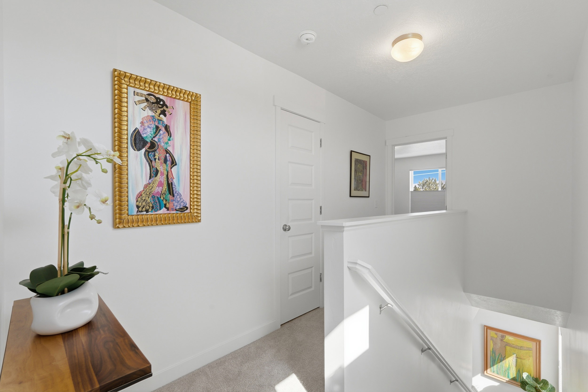 Light filled hallway with an upstairs landing