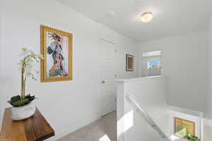 Light filled hallway with an upstairs landing