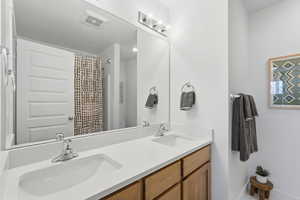 Primary bathroom featuring double sinks and quartz countertops