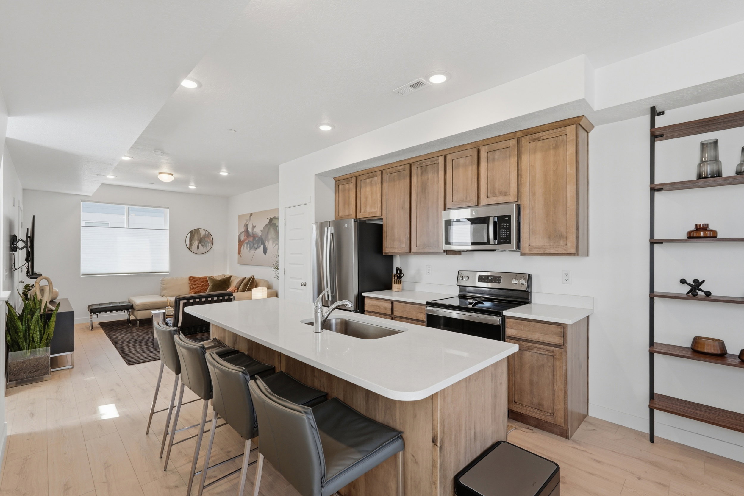 Kitchen with wood shaker-style cabinetry, quartz countertops, and stainless steel appliances. The 8-foot kitchen island is perfect for extra seating and entertaining.