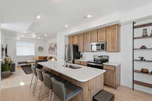 Kitchen with wood shaker-style cabinetry, quartz countertops, and stainless steel appliances. The 8-foot kitchen island is perfect for extra seating and entertaining.