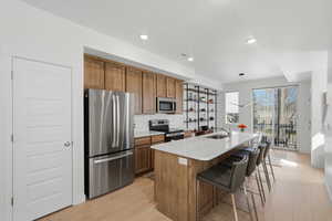Kitchen with wood shaker-style cabinetry, quartz countertops, and stainless steel appliances. The 8-foot kitchen island is perfect for extra seating and entertaining.