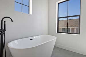 Full bath featuring a freestanding tub and tile patterned flooring