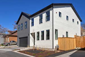 View of property exterior featuring an attached garage, board and batten siding, and concrete driveway