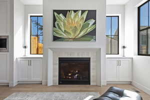 Living room with a tile fireplace and light wood finished floors