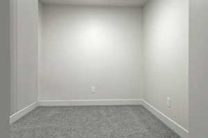 Spare room with light colored carpet and baseboards