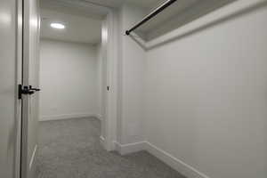Walk in closet featuring light colored carpet