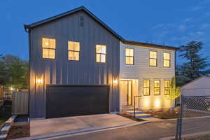 View of front of home with board and batten siding, a garage, and driveway