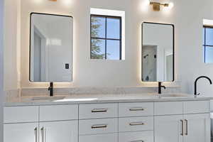 Bathroom with double vanity and a marble finish shower