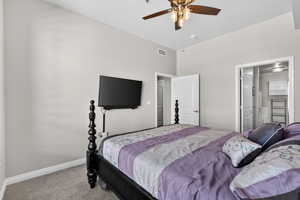 Bedroom with light carpet, ceiling fan, and ensuite bathroom