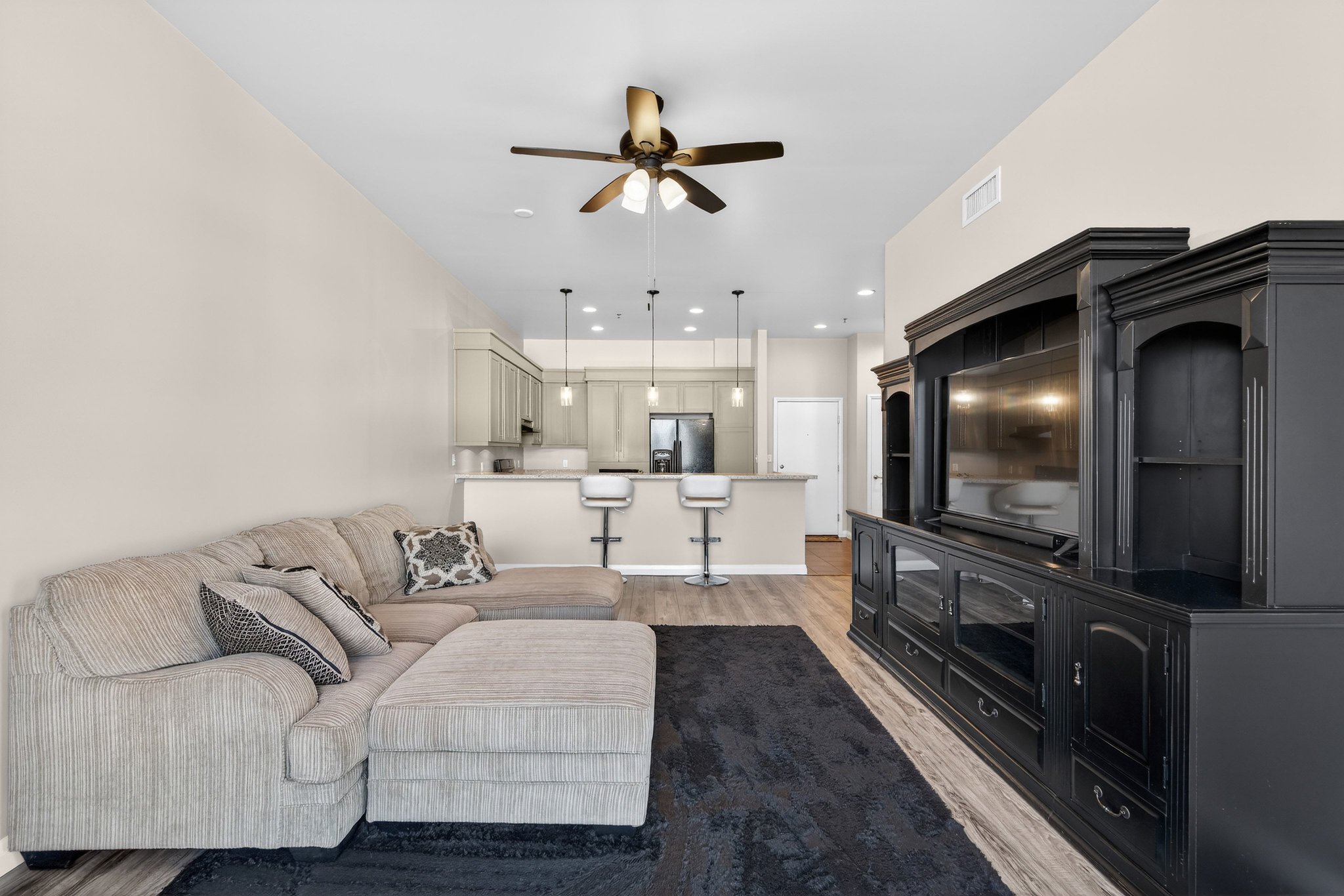Living room featuring light wood-type flooring, ceiling fan, and recessed lighting