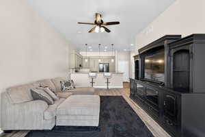 Living room featuring light wood-type flooring, ceiling fan, and recessed lighting
